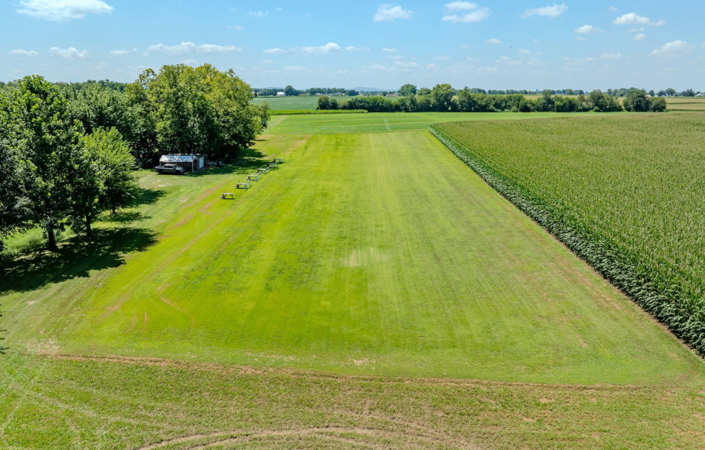 RC aircraft operating over a maintained grass flying field runway